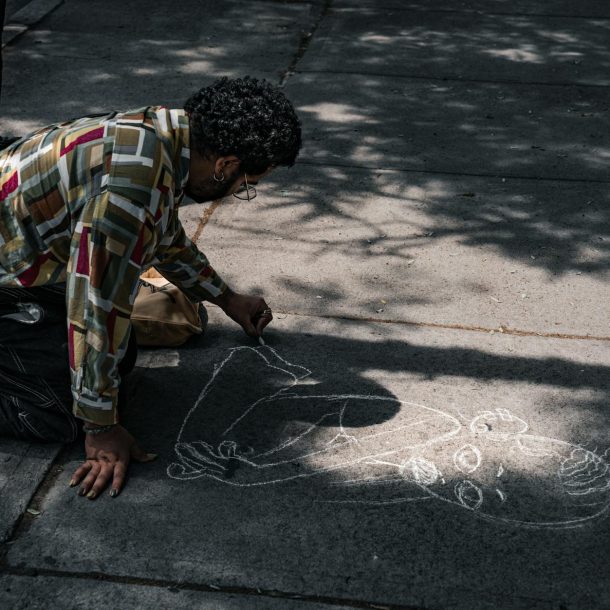 a man drawing on the sidewalk with chalk