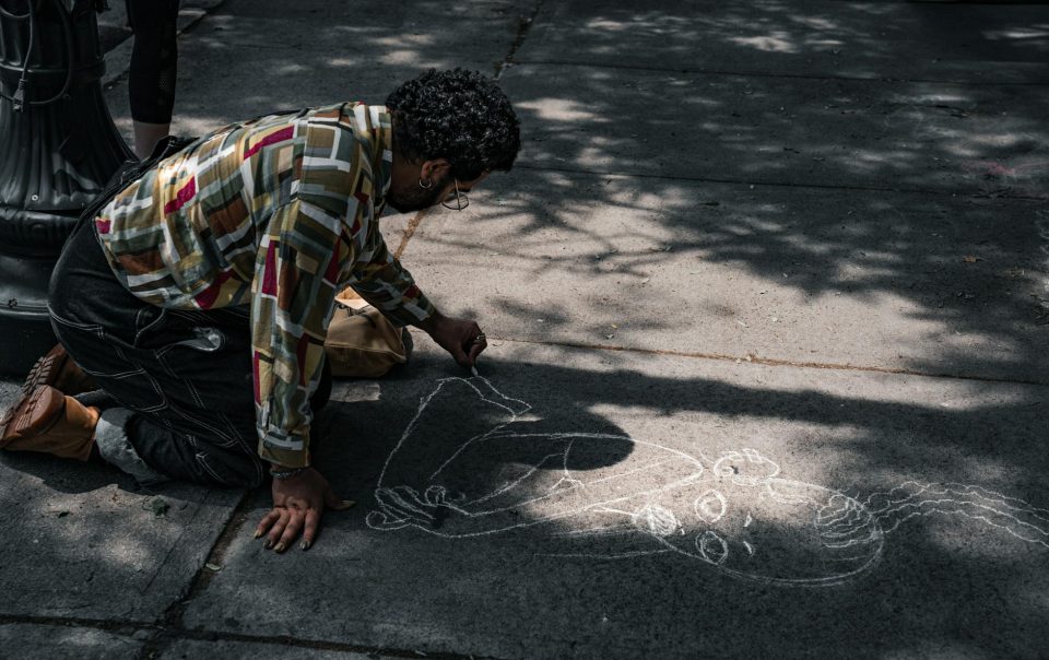 a man drawing on the sidewalk with chalk